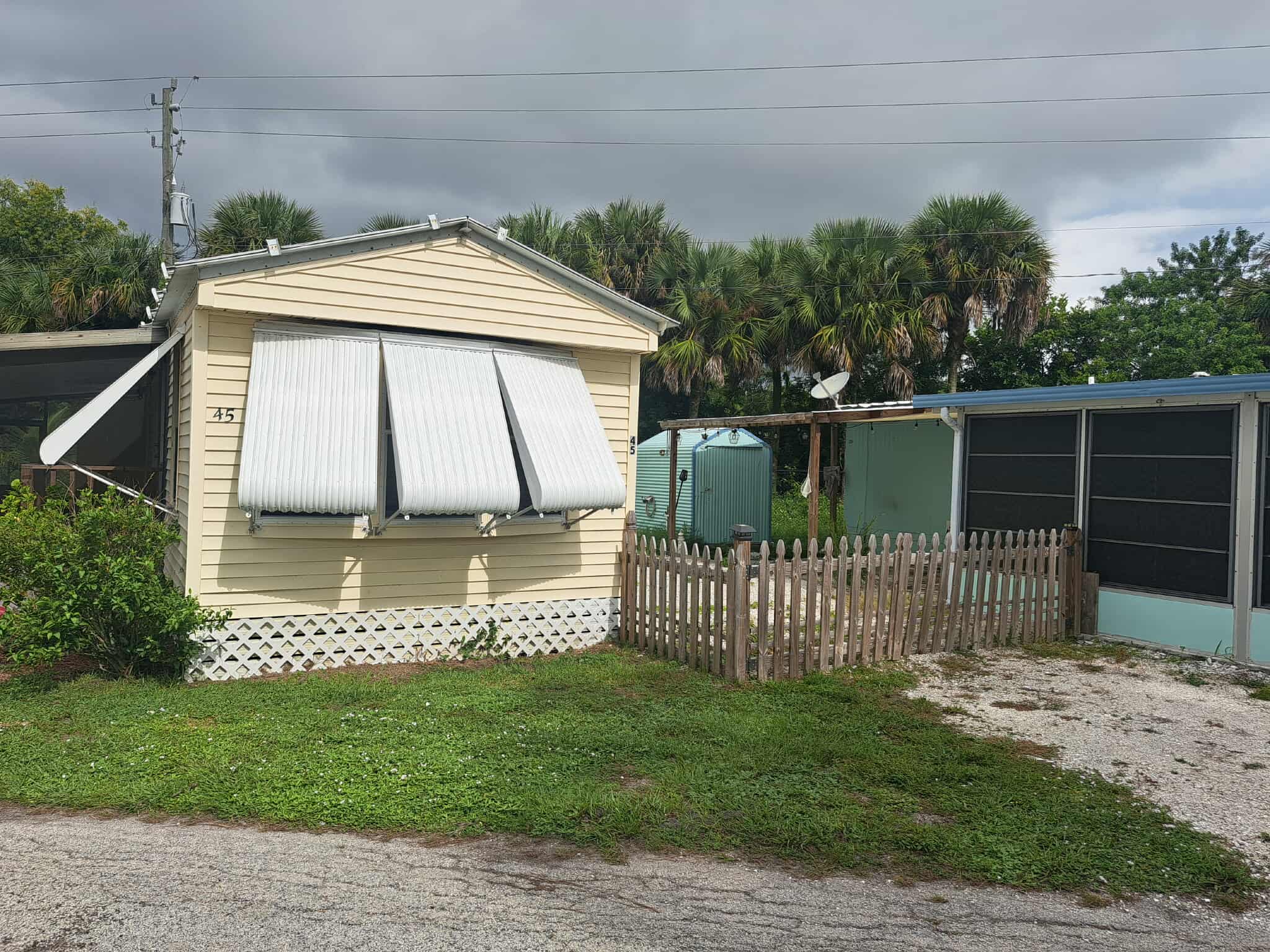 Beige park model with fenced yard at Twin Rivers RV Park