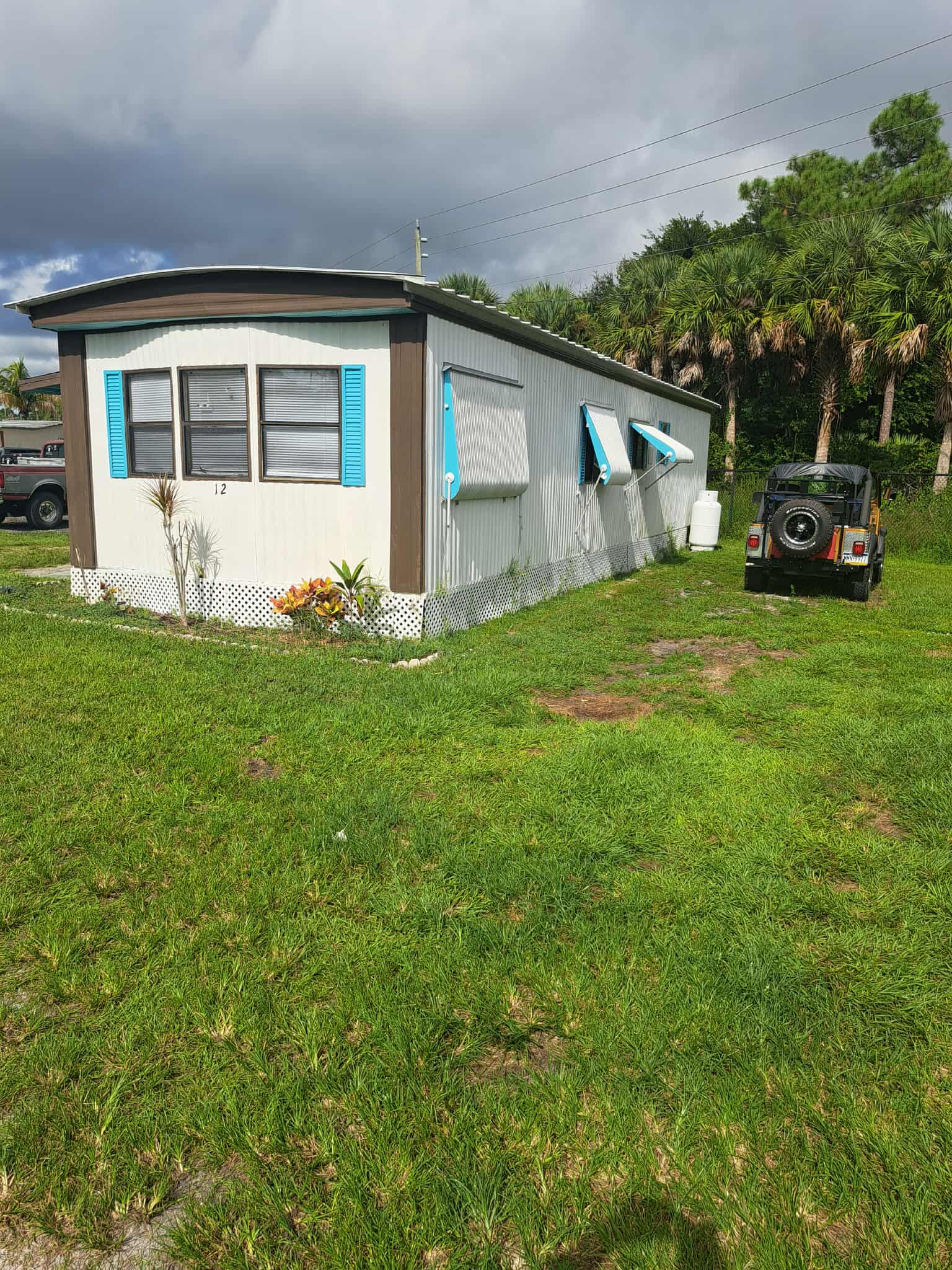 Park model mobile home with teal shutters available for rent